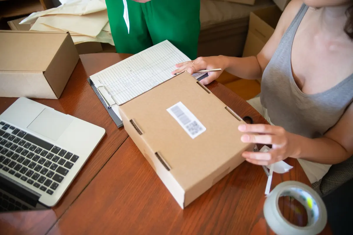 Ein Paket wird neben einem Laptop für den Transport vorbereitet