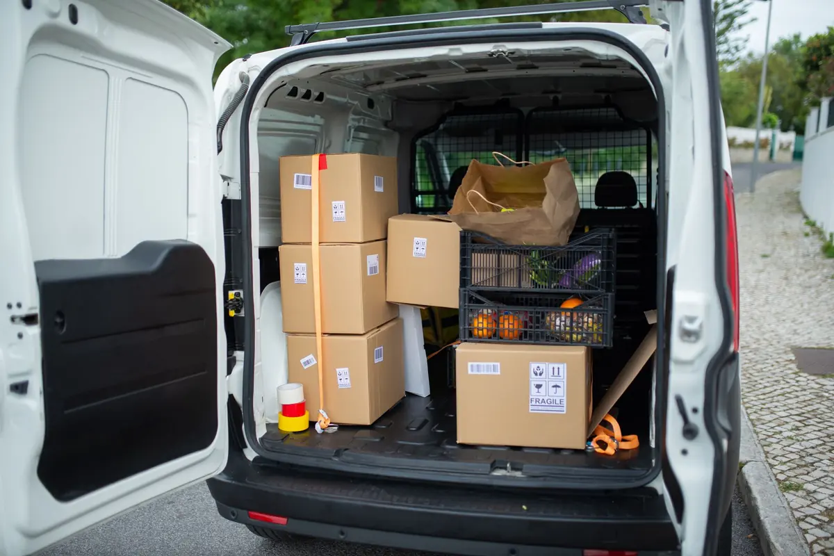 Kartons und Taschen stehen geordnet im Ladebereich eines Transporters