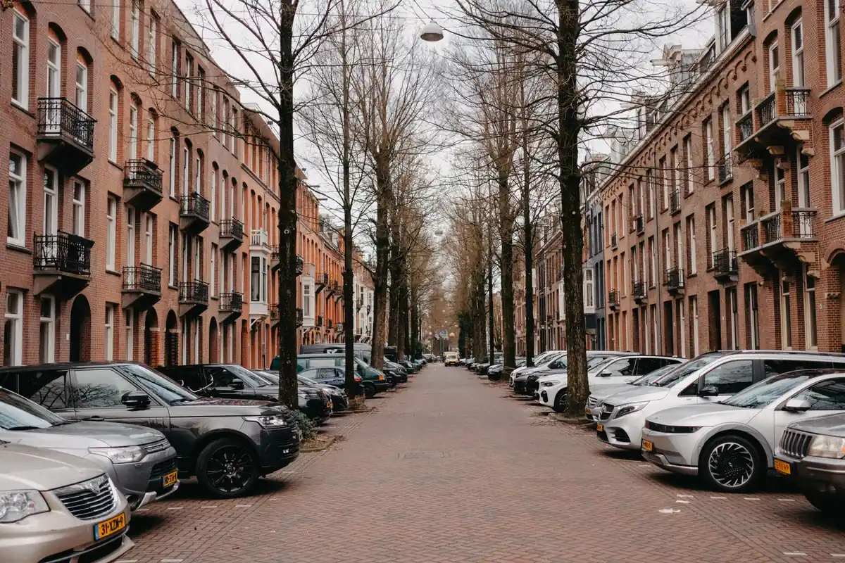 Eine ruhige europäische Wohnstraße mit Backsteinfassaden und parkenden Autos